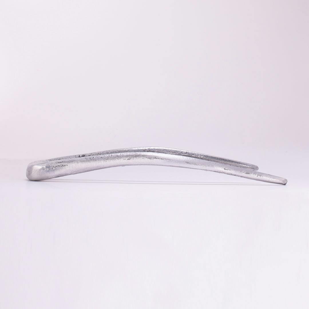 A full product image of THE FANG, a silvery, aluminium two-tined tool, positioned on its left hand side.